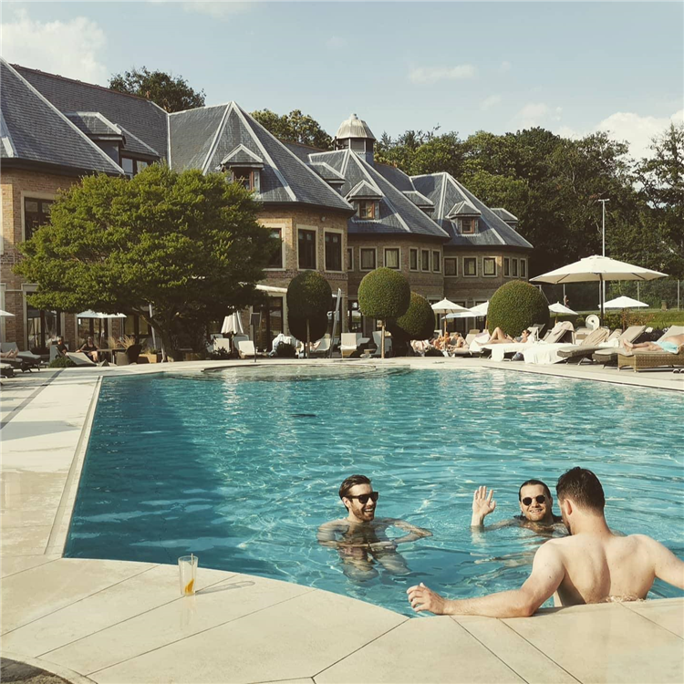 three men in a hotel pool